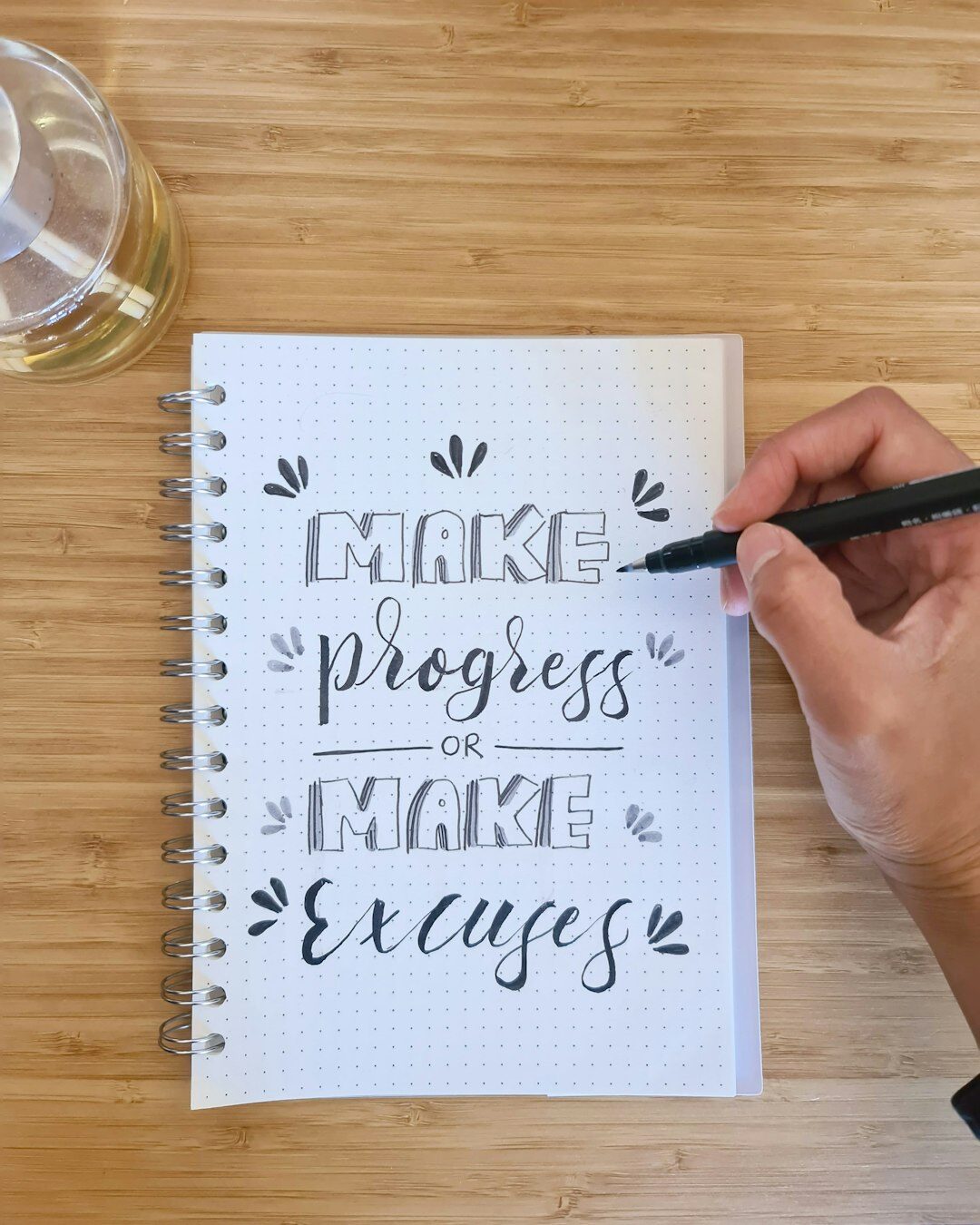 Hands writing personal development goals in a notebook