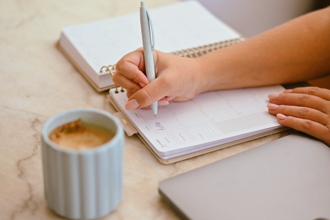 person writing goals in notebook