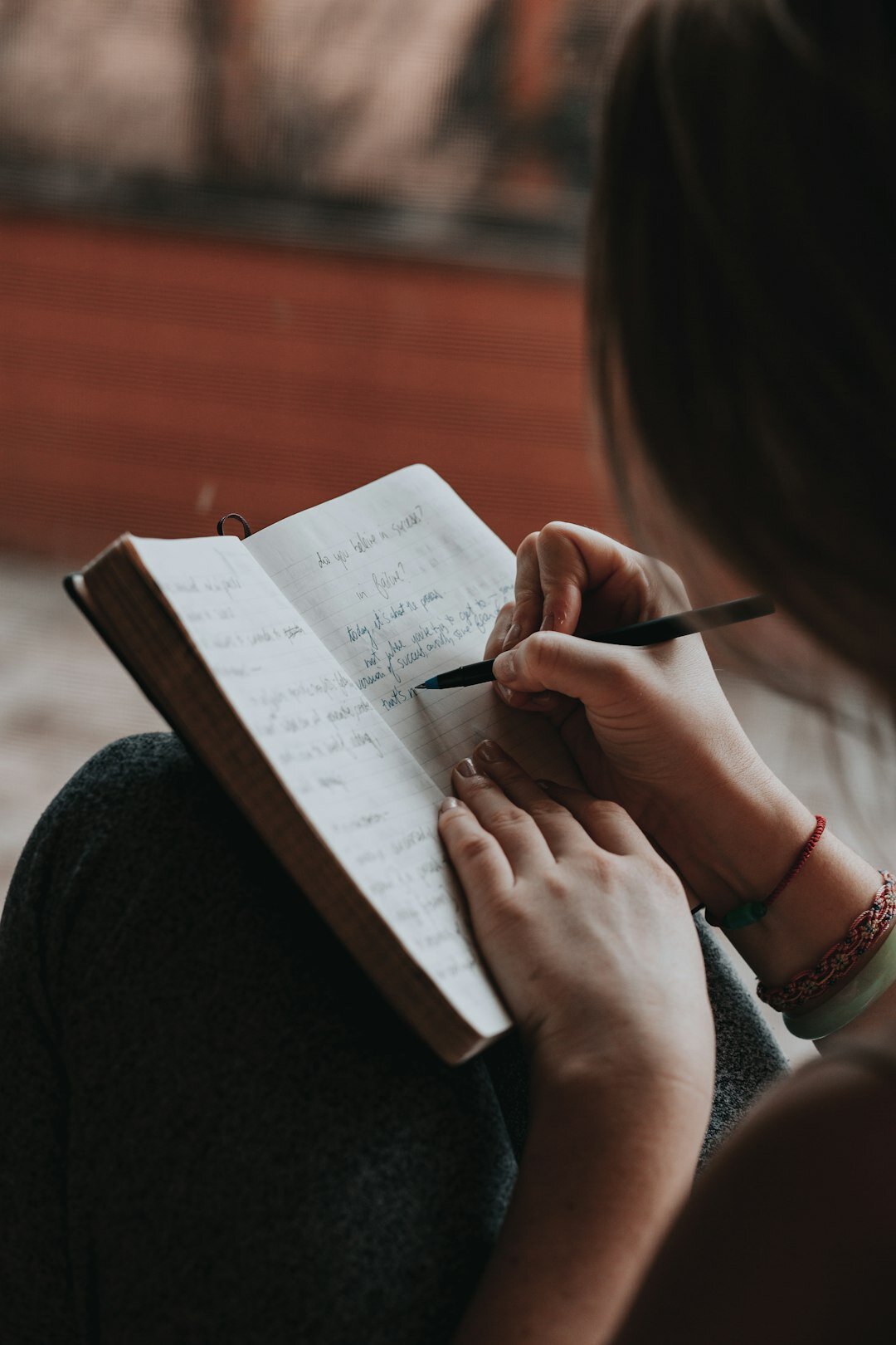 person writing notes in notebook